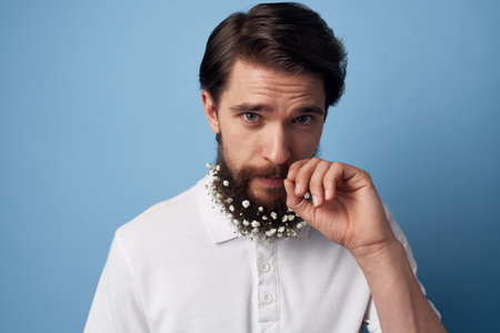 Man in white shirt beard with flowers decorating blue backgroundの写真素材