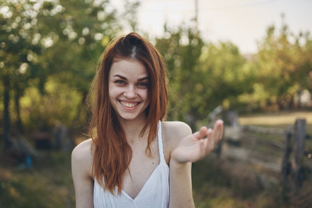 happy woman gesturing with hands outdoors in garden summer trees vacationの写真素材
