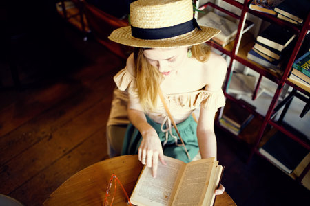 Pretty woman in hat with book reading vacation interiorの写真素材
