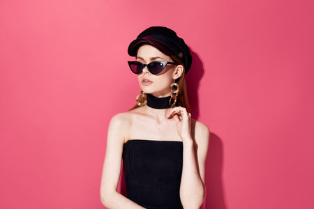 Elegant woman in black glasses evening dress decorating the glamorous pink background