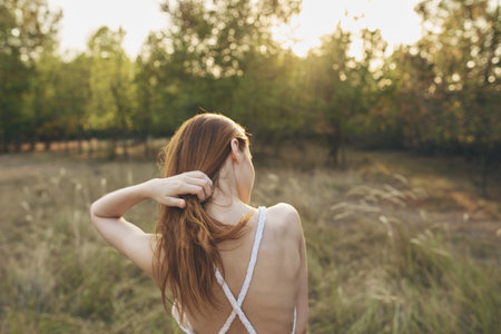woman on a meadow in nature and summer trees vacation model sunの写真素材
