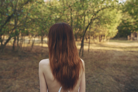 romantic woman outdoors in the garden back view model red hairの写真素材