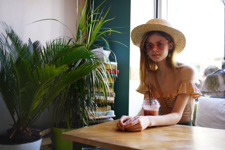 Woman in the library sits at the table reading leisure interiorの写真素材