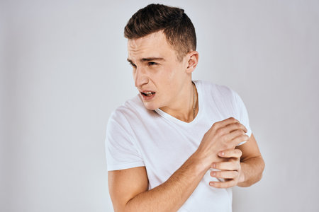 Man in white t-shirt displeased facial expression gesturing with hands studio lifestyleの写真素材
