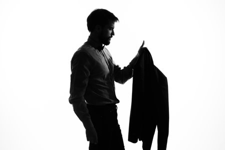 man in a suit holding a jacket in his hands emotions profile silhouette shadowの写真素材