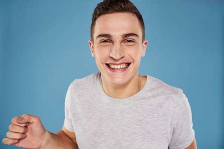 cute emotional man in white t-shirt gesture with hands blue background