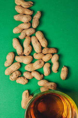 beer mug peanuts in shells bar alcohol green background