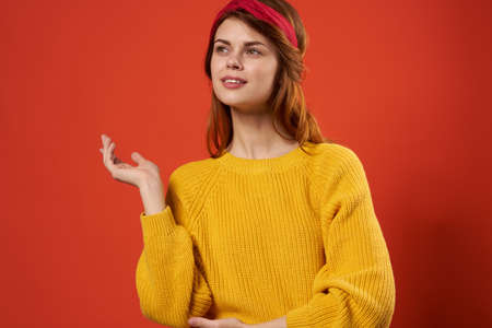pretty woman wearing yellow sweater red headband hippie street style red backgroundの写真素材