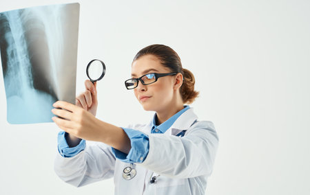 Doctor woman with magnifying glass and chest x-ray in hand