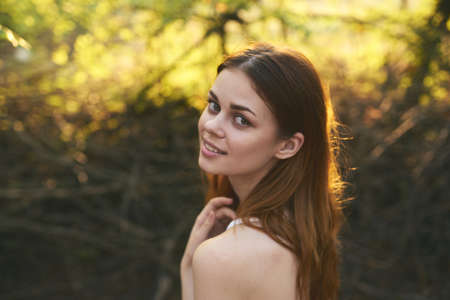 happy red-haired woman on nature in the forest near green trees Summer sunの写真素材