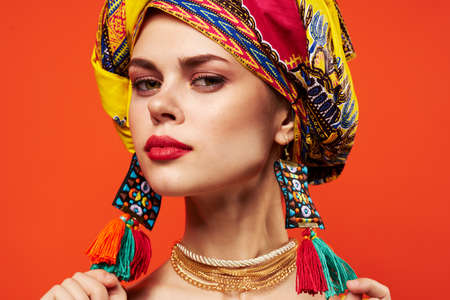 woman wearing multicolored turban decoration attractive look ethnicity red backgroundの写真素材