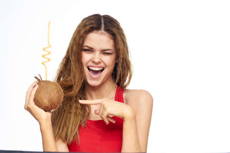 Beautiful woman with coconut cocktail in hands wavy hair cosmetics attractive look lifestyle leisureの写真素材