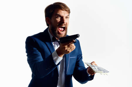male gangster with a wad of money and a gun in hand in a classic gangster suitの写真素材