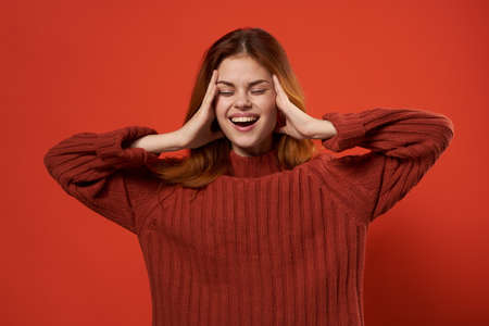pretty woman gesturing with hands red sweater close-up studioの写真素材