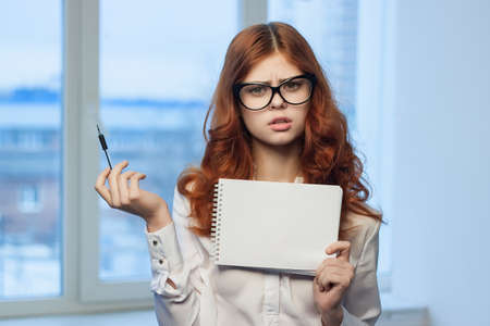 Business woman in white shirt with notebook in hands of office professionals