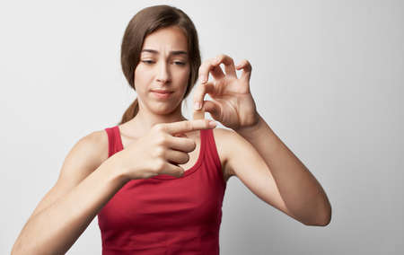 woman with broken finger in red t-shirt injury health problemsの写真素材