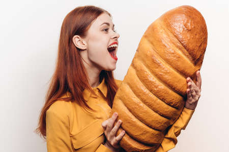 surprised woman examines a loaf in her hands on a light background