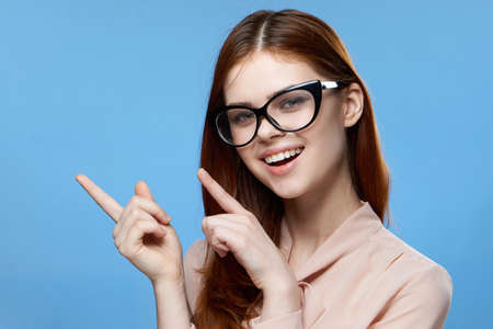 cheerful woman gesturing with finger wearing glasses emotions cropped view blue backgroundの写真素材