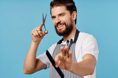 professional hairdresser in gray aprons fashionable hairstyle bushy beard scissors comb manの写真素材