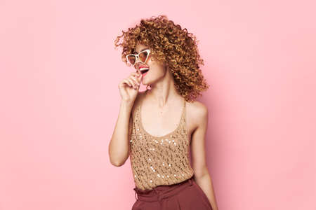 Pretty woman Curly hair sunglasses fashion pink backgroundの写真素材