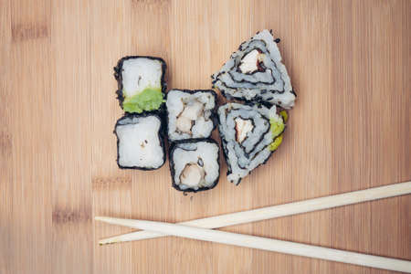 triangular sushi rolls chopsticks wooden background Japanese kitchenの写真素材