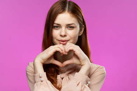 cheerful attractive woman gesturing with glamor hands luxury studio pink backgroundの写真素材