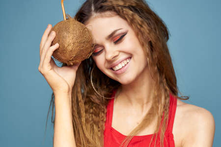 woman with coconut cocktail in hands wavy hair bright makeup lifestyle studio summer vacationの写真素材