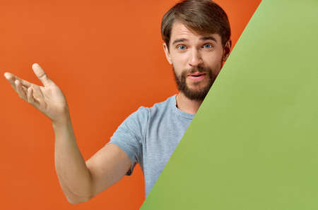 bearded man in gray t-shirt green mockup poster orange backgroundの写真素材