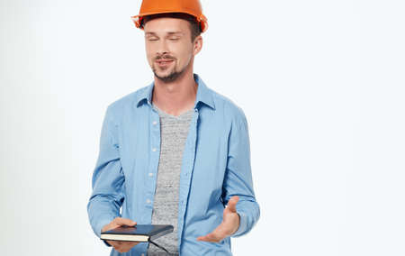 male architect in orange hard hat working gray background cropped viewの写真素材