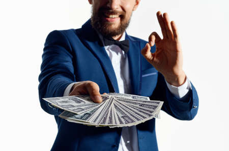 a man in a classic suit with a wad of money banknote business finance modelの写真素材