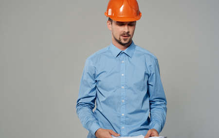 male architect in orange hard hat working gray background cropped viewの写真素材