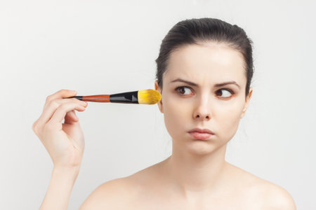 woman with bare shoulders as face mask brush for applying skin careの写真素材