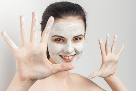 brunette brushing cream on face skin care cropped viewの写真素材