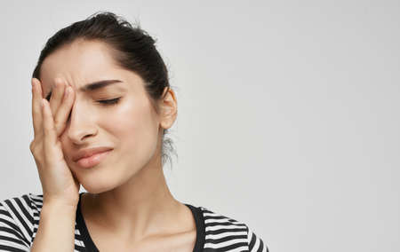 brunette in a striped t-shirt health problems headache migraineの写真素材