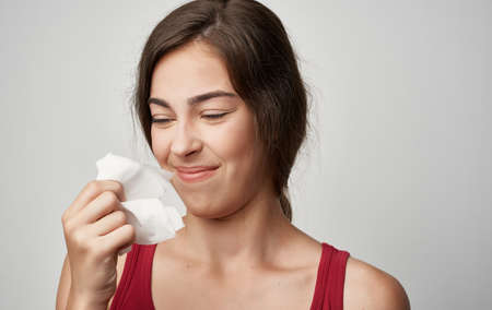 sick woman in red t-shirt health problems cold allergyの写真素材