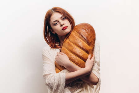 beautiful woman hugging loaf with her hands makeup transparent fabric on her shouldersの写真素材