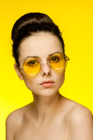 pretty woman with bare shoulders yellow glasses emotions cropped viewの写真素材