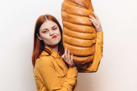 woman with a loaf in her hands on a light background emotions model funの写真素材