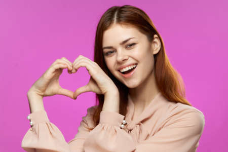 pretty woman gesturing with hands glamor fashion fun pink background close-upの写真素材