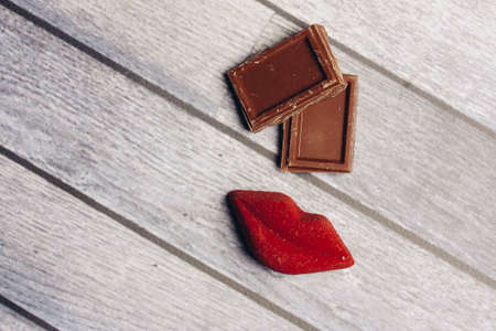 sweets milk chocolate red lips marmalade meal wooden backgroundの写真素材