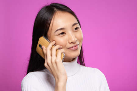cute asian woman talking on the phone internet communication technologyの写真素材