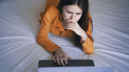 woman lying in bed laptop communication rest at home
