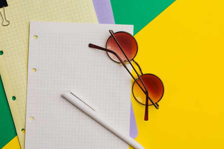 multicolored sheets of paper on colored background and pen office notepad clip glassesの写真素材