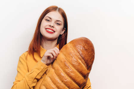 pretty woman with a loaf in her hands on a light background red lips makeup model