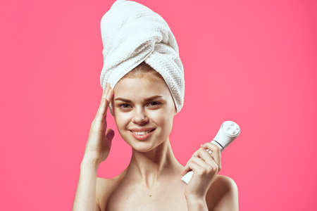 attractive women on naked shoulders towel on head massager in hands skin careの写真素材