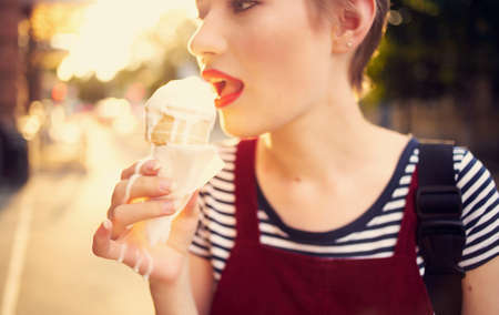 pretty woman with short hair eating ice cream outdoors leisure walkの写真素材