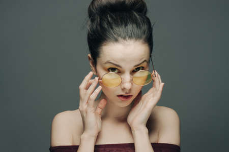 brunette with bare shoulders clear skin gray backgroundの写真素材