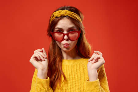 attractive red-haired woman wearing red glasses yellow sweater casual clothing lifestyle street styleの写真素材