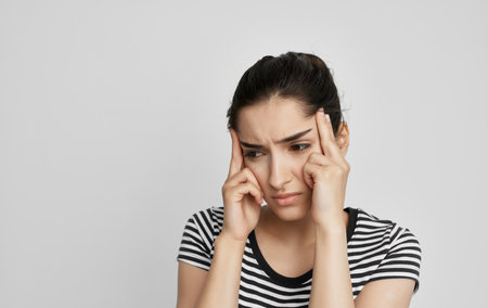 woman in t-shirt holding her head discontent health problem