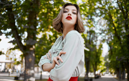 romantic woman in shirt skirt walking in the park in summer near green treesの写真素材